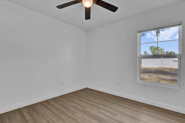 empty room featuring light wood-type flooring, ceiling fan, and baseboards