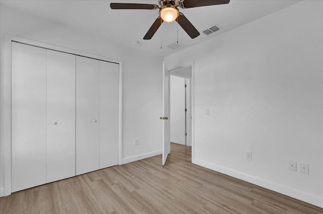 unfurnished bedroom featuring light wood finished floors, a closet, visible vents, ceiling fan, and baseboards