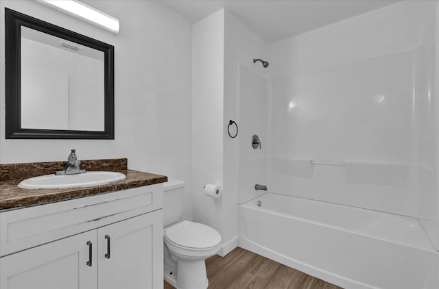 full bath with toilet, wood finished floors, visible vents, vanity, and bathing tub / shower combination