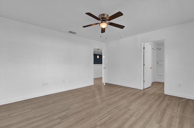 unfurnished room featuring light wood-type flooring, baseboards, visible vents, and a ceiling fan