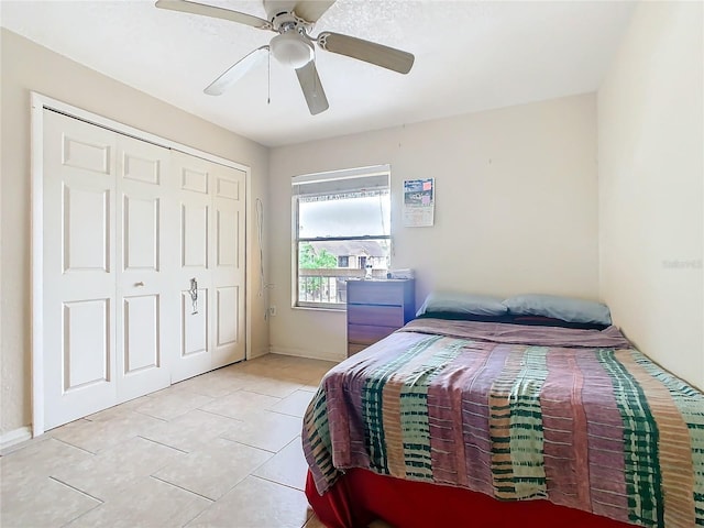 bedroom featuring a ceiling fan, a closet, and light tile patterned floors