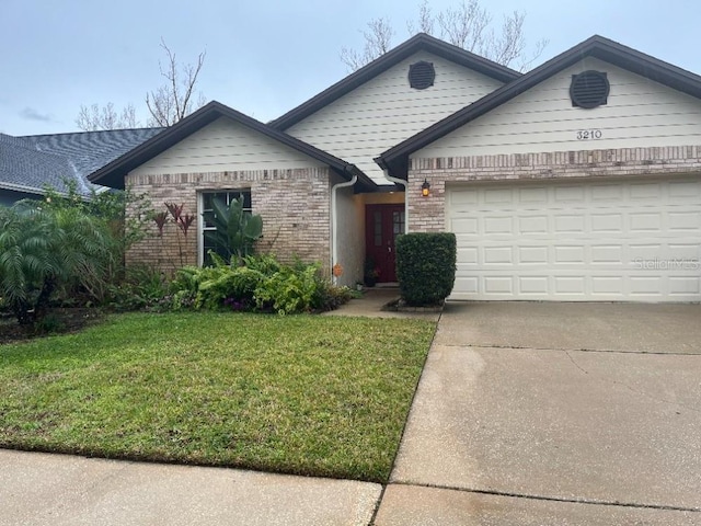 ranch-style home featuring a garage, a front yard, concrete driveway, and brick siding