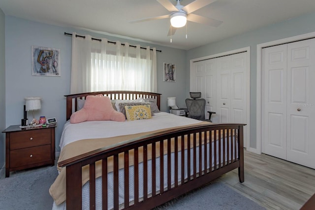 bedroom with multiple closets, a ceiling fan, and wood finished floors