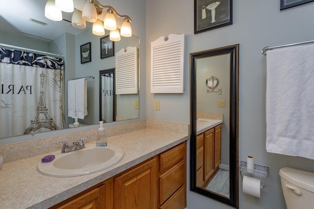 bathroom featuring toilet, visible vents, and vanity