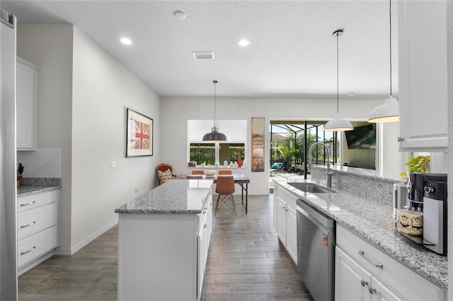 kitchen with dishwasher, wood finished floors, a sink, and white cabinets