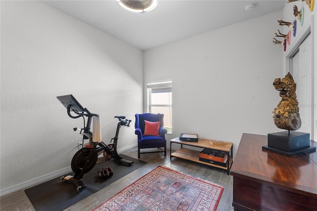 exercise area with baseboards and wood finished floors