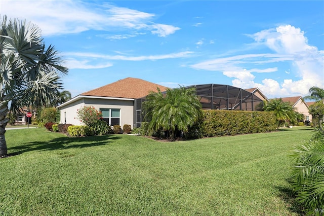 back of property with a lawn and stucco siding