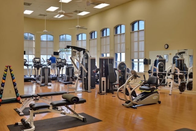 workout area with a towering ceiling and wood finished floors