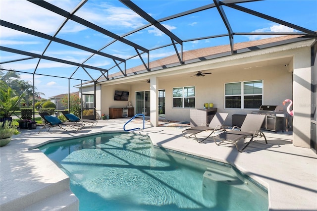 outdoor pool with an outdoor kitchen, a ceiling fan, a lanai, a grill, and a patio area