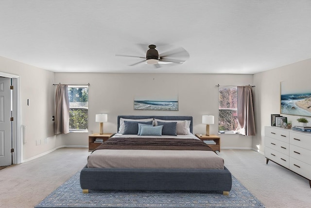 bedroom featuring baseboards, a ceiling fan, and light colored carpet