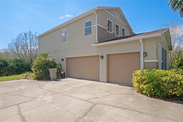 view of home's exterior with driveway, an attached garage, and stucco siding