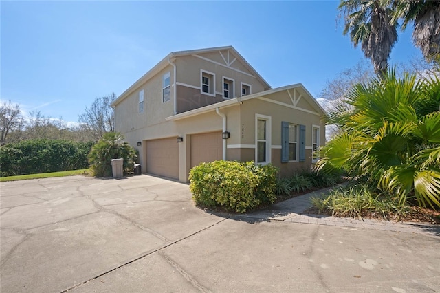 view of home's exterior with a garage, driveway, and stucco siding