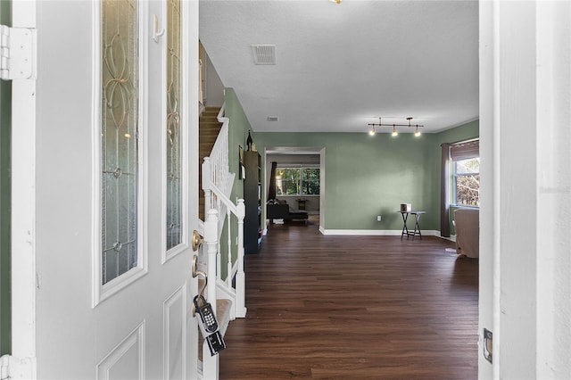 entryway featuring baseboards, visible vents, wood finished floors, stairs, and a textured ceiling