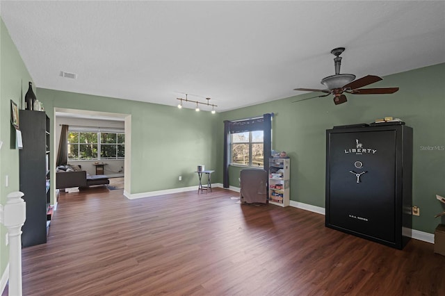 interior space with baseboards, visible vents, ceiling fan, and wood finished floors