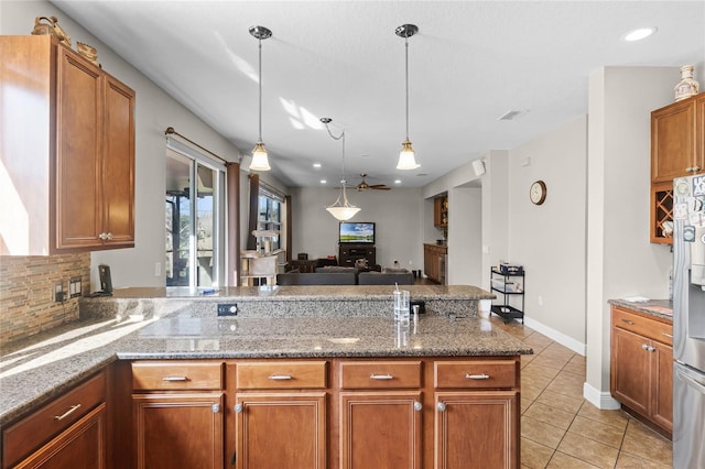 kitchen featuring light tile patterned floors, visible vents, backsplash, open floor plan, and a peninsula