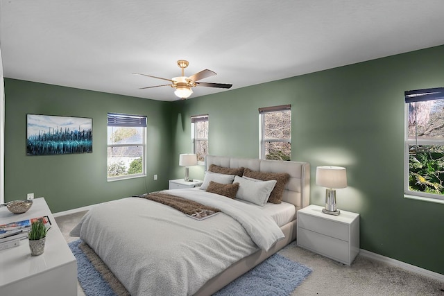 bedroom with ceiling fan, baseboards, and light colored carpet