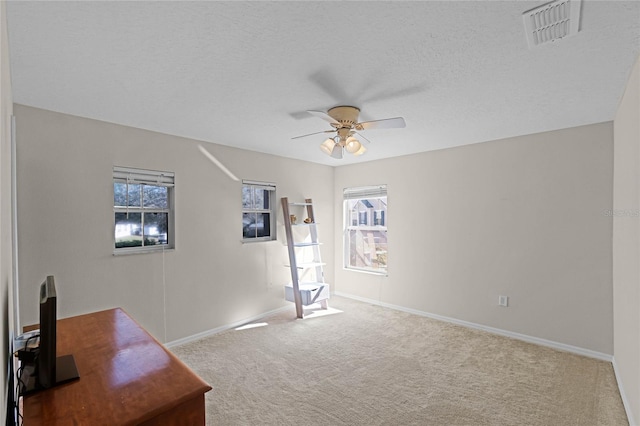 office with baseboards, visible vents, ceiling fan, a textured ceiling, and carpet floors