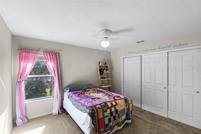 carpeted bedroom featuring baseboards, visible vents, a ceiling fan, a textured ceiling, and a closet