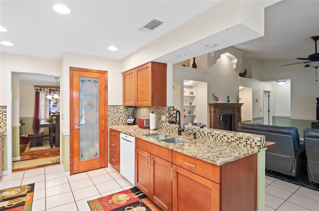 kitchen with a peninsula, a sink, open floor plan, brown cabinets, and dishwasher