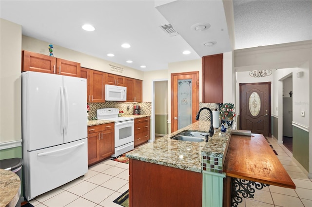 kitchen with light tile patterned floors, visible vents, a sink, white appliances, and a peninsula