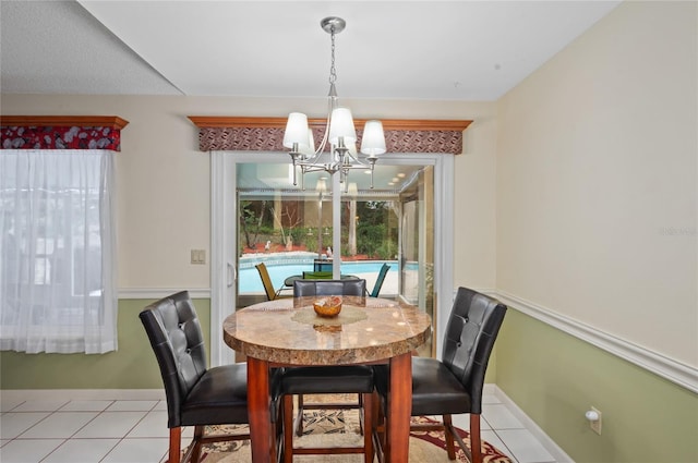 dining space with a notable chandelier, baseboards, and light tile patterned floors