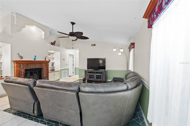 living room with visible vents, built in features, vaulted ceiling, a textured ceiling, and a fireplace