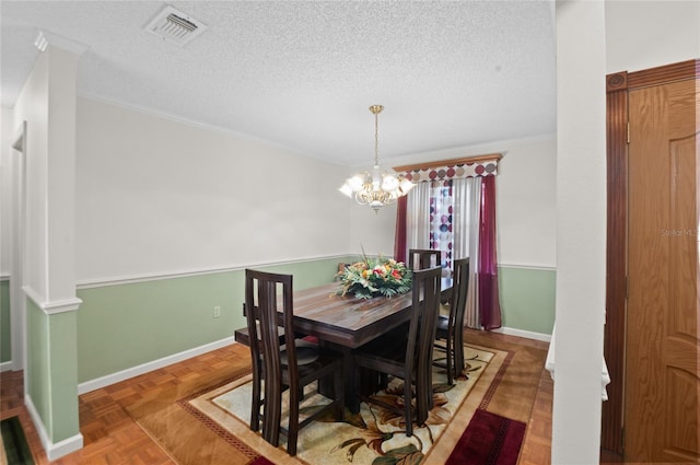 dining space featuring a chandelier, visible vents, a textured ceiling, and baseboards