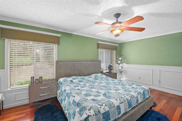 bedroom with ornamental molding, dark wood-type flooring, a textured ceiling, and wainscoting