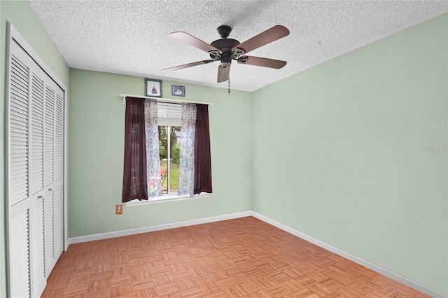 unfurnished bedroom featuring a closet, a textured ceiling, and baseboards