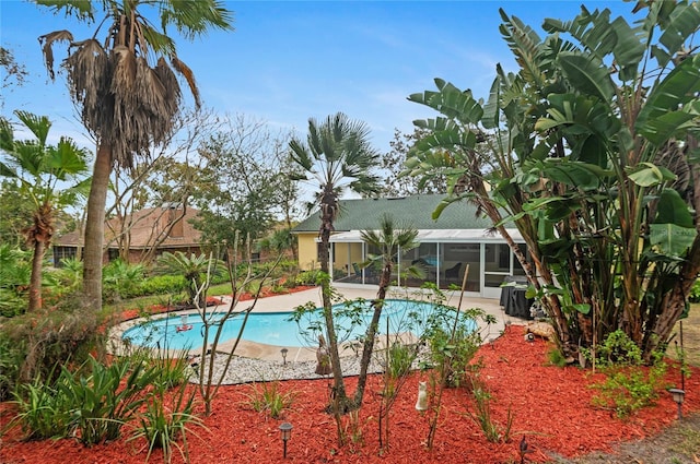 outdoor pool with glass enclosure and a patio