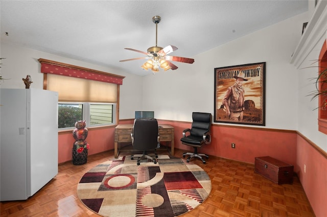 home office featuring a ceiling fan, vaulted ceiling, and a textured ceiling