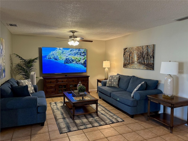 living room with a ceiling fan, light tile patterned floors, visible vents, and a textured ceiling