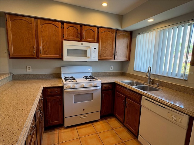 kitchen featuring brown cabinets, light countertops, light tile patterned flooring, a sink, and white appliances