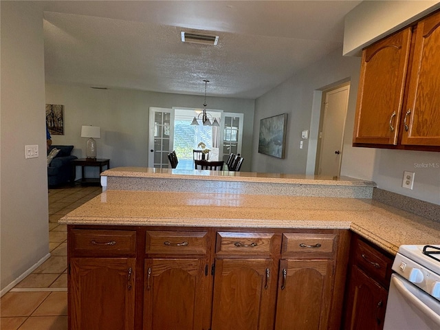 kitchen featuring visible vents, open floor plan, light countertops, and a peninsula