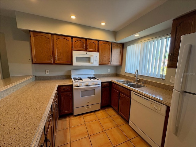 kitchen featuring recessed lighting, white appliances, a sink, light countertops, and brown cabinets