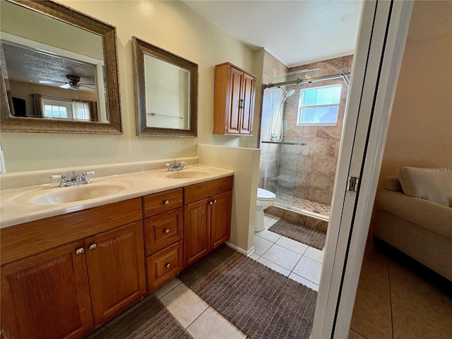 bathroom featuring tile patterned flooring, a sink, a shower stall, and toilet