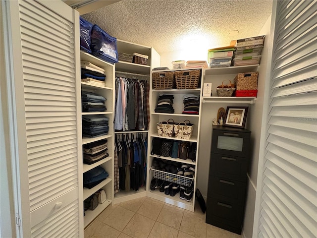 walk in closet with light tile patterned floors