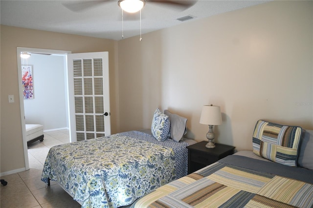 bedroom featuring a ceiling fan, visible vents, baseboards, and light tile patterned flooring