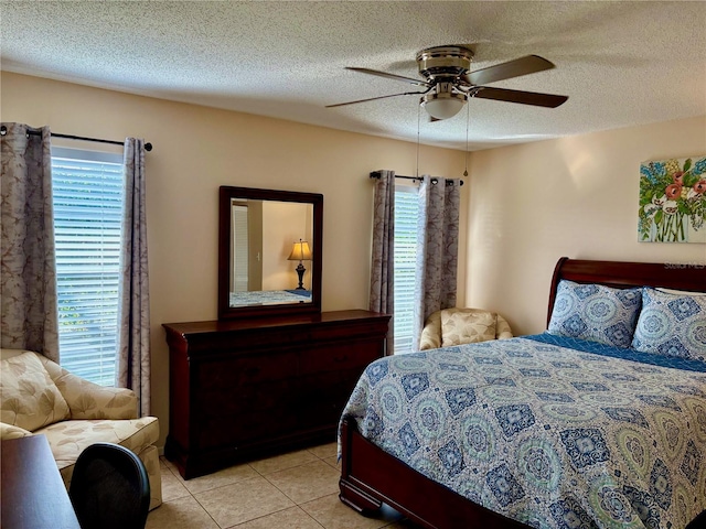 bedroom featuring a ceiling fan, a textured ceiling, and light tile patterned floors