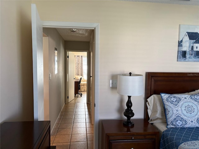 bedroom with light tile patterned floors and a textured ceiling