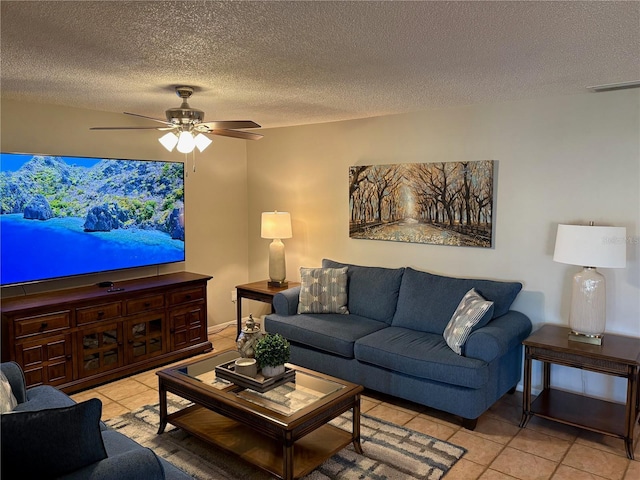 living area featuring a ceiling fan, visible vents, a textured ceiling, and light tile patterned flooring