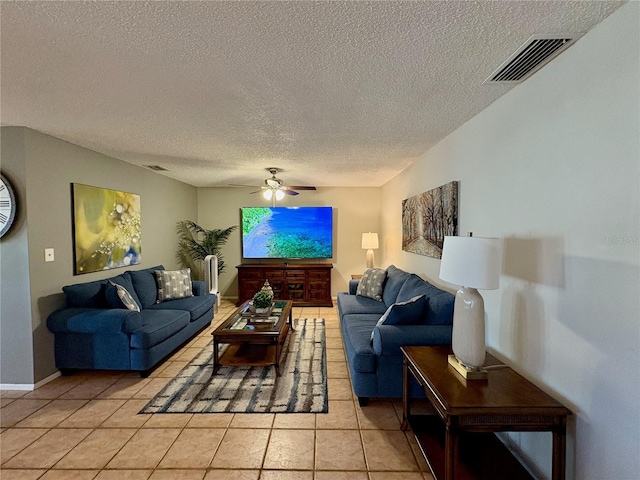 living area with a ceiling fan, visible vents, a textured ceiling, and light tile patterned floors