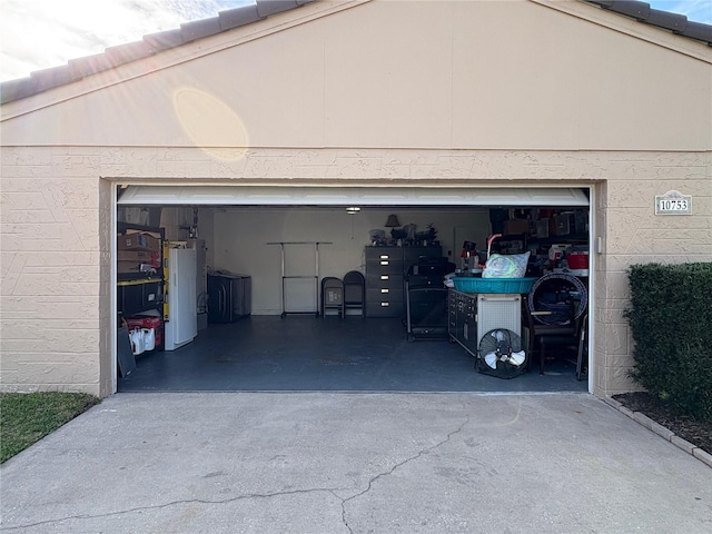 garage with water heater and driveway