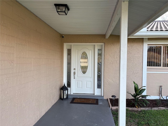 doorway to property featuring stucco siding