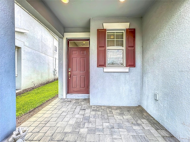 view of exterior entry featuring stucco siding