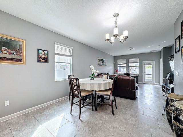 dining room with an inviting chandelier, visible vents, baseboards, and a textured ceiling