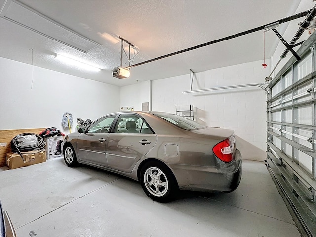 garage with concrete block wall and a garage door opener