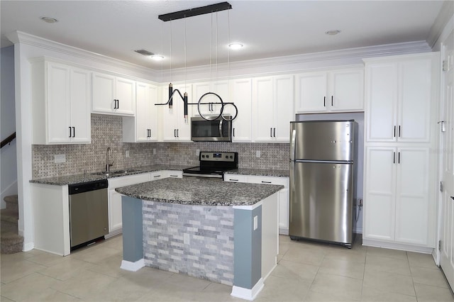 kitchen with a sink, stainless steel appliances, dark stone counters, white cabinets, and decorative backsplash