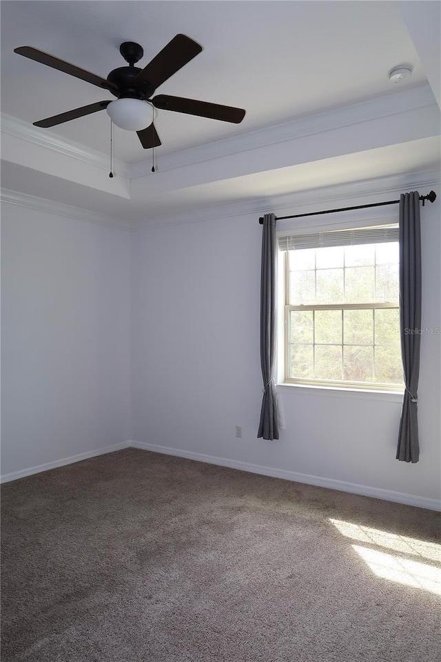 unfurnished room featuring carpet flooring, a raised ceiling, baseboards, and ornamental molding