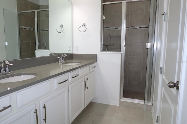 bathroom featuring tile patterned floors, a shower stall, double vanity, and a sink